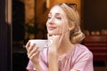 Close-up portrait shot of happy young woman drinking coffee at the cafe Royalty Free Stock Photo