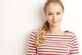 Studio portrait of pretty young woman lookig at camera and smiling while standing at isolated white background and playing with Royalty Free Stock Photo