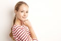 Studio portrait of pretty young woman lookig at camera and smiling while standing at isolated white background and playing with Royalty Free Stock Photo