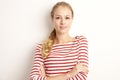 Studio portrait of pretty young woman lookig at camera and smiling while standing at isolated white background and playing with Royalty Free Stock Photo