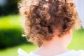 Portrait shot of a child with curly hair and back turned
