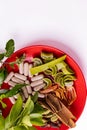 Portrait shot Close-up view of arranged whole Spices with ayurvedic capsules, green leaves and sliced aloe vera in a plate on