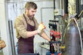 Bearded Worker Using Bottle Capper