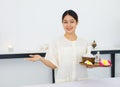 Portrait shot Millennial Asian professional female masseuse aromatherapy therapist in uniform standing smiling holding equipment Royalty Free Stock Photo