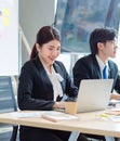 Portrait shot of Millennial Asian young professional successful female businesswoman in formal suit sitting smiling posing look at Royalty Free Stock Photo