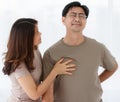 Portrait shot of senior Asian lover couple wearing eyeglasses. Husband suddenly feels uncomfortable from acute back pain with Royalty Free Stock Photo