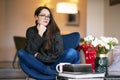 Relaxed young woman with beautiful smile sitting on the chair in the living room Royalty Free Stock Photo