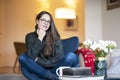 Relaxed young woman with beautiful smile sitting on the chair in the living room Royalty Free Stock Photo