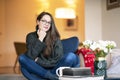 Relaxed young woman with beautiful smile sitting on the chair in the living room Royalty Free Stock Photo