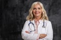 Smiling blond haired female doctor standing at isolated background Royalty Free Stock Photo