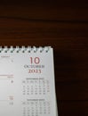 Portrait shot of a table with a calendar page open to the date October 10th, 2023