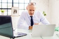 Portrait shot of stressed businessman working on laptop at the office Royalty Free Stock Photo