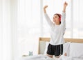 Portrait shot of a young adult Asian woman in casual white clothes closed her eyes, raising her arms up and enjoy listening to the Royalty Free Stock Photo