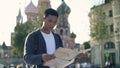 Portrait shot of a young Asian man looking at map. The Cathedral of Vasily the Blessed on background, Moscow Russia. Red Royalty Free Stock Photo