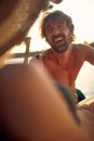 Portrait shot of young man smilling and enjoying his time with girlfriend. Couple by sea on vacation. Summertime, holiday, fun, Royalty Free Stock Photo