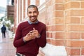 I cant go anywhere without technology in hand. Portrait shot of a young man texting on a cellphone outside. Royalty Free Stock Photo