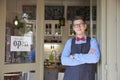 Small business owner standing in the cafe entrance with open sign while wating for guest Royalty Free Stock Photo