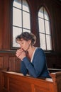 Young woman with closed eyes praying in the church Royalty Free Stock Photo