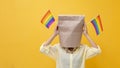 Portrait of shy LGBTQ people covering her face waving rainbow flag for coming out of the closet in pride month to promote marriage