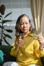 Portrait of a sick asian aged woman drinking water and taking a medicine Royalty Free Stock Photo