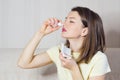 Portrait of sick girl with runny nose, rhinitis, allergies, colds. woman holds medical spray in hand. Royalty Free Stock Photo