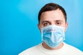 Portrait of a sick man wearing medical mask with infection text at blue background. concept. Protect your health Royalty Free Stock Photo