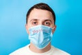 Portrait of a sick man wearing medical mask with Stay home text at blue background. Coronavirus self isolation concept. Protect Royalty Free Stock Photo