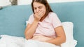 Portrait of sick pregnant woman feeling nausesa and coughing while lying in bed at morning. Healthcare and intoxication Royalty Free Stock Photo