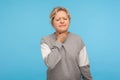 Portrait of sick unhappy adult woman with curly hair in sweatshirt touching neck suffering sore throat, painful swallowing Royalty Free Stock Photo