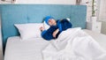 Portrait of sick woman suffering from headache with wet compress on head lying in bed Royalty Free Stock Photo