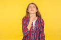 Portrait of sick young woman in checkered shirt touching sore neck, grimacing from pain, aching tonsils Royalty Free Stock Photo