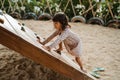 Portrait from a side view a little girl start trying climb on the wooden board climb