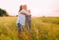 Portrait of a sincerely smiling young pregnant woman dressed in light summer clothes embracing with mother in evening sunset hours Royalty Free Stock Photo