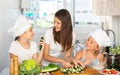 Young woman and two girls cooking together Royalty Free Stock Photo
