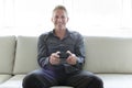 Portrait of single 40s man sitting in sofa play video game Royalty Free Stock Photo