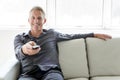 Portrait of single 40s man sitting in sofa tv remote Royalty Free Stock Photo