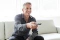 Portrait of single 40s man sitting in sofa tv remote Royalty Free Stock Photo