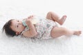 Portrait of six months crawling baby holding milk bottle on fluffy white rug, happy smiling adorable sweet little girl kid lying Royalty Free Stock Photo