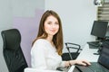 Portrait of skilled administrative manager working on laptop computer in office satisfied with occupation, young female receptioni