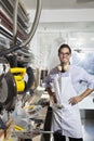 Portrait of a skilled worker standing with hands on hips in workshop