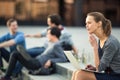 Portrait of a sleek young woman, using laptop computer, being pensive in urban/city context