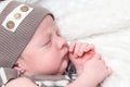 Portrait of a sleeping infant baby boy in a striped suit and hat Royalty Free Stock Photo