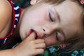 Portrait of sleeping pretty child girl who sucks her finger while sleeping. Royalty Free Stock Photo