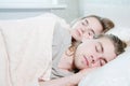 Portrait of a sleeping young couple on a bed with white bedding. Pandemic and Isolation and Quarantine Concept. Sleep as Royalty Free Stock Photo