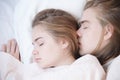 Portrait of a sleeping young couple on a bed with white bedding. Pandemic and Isolation and Quarantine Concept. Sleep as Royalty Free Stock Photo