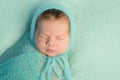 Portrait of sleepy newborn with wrapped head and body Royalty Free Stock Photo