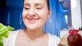 Portrait of young sleepy woman looking for something to eat in refrigerator Royalty Free Stock Photo