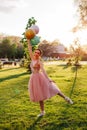 portrait of slender ballerina in a pink silk dress and white pointe shoes, standing and balancing on one hand with Royalty Free Stock Photo