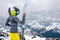 Portrait of a slender girl in a buff and a balaclava in a ski mask and a hat with a closed face next to skis against the