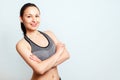 Portrait of a slender happy sports woman in a tank top, on a light blue background. with copyspace